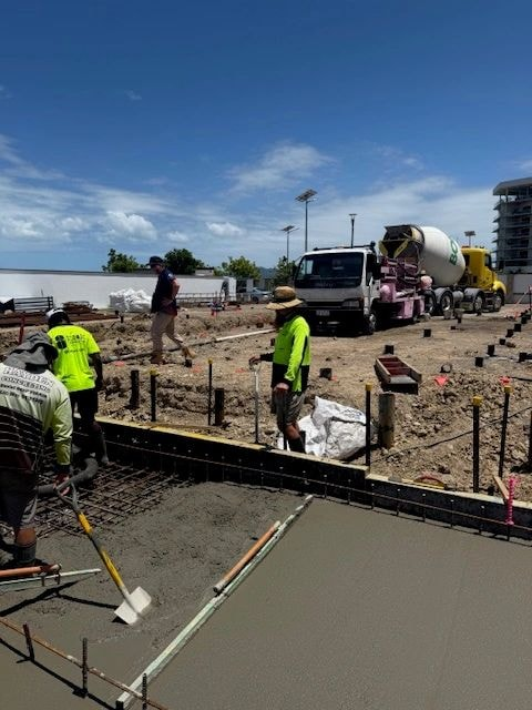 Concrete pour under elevated building with pump hose
