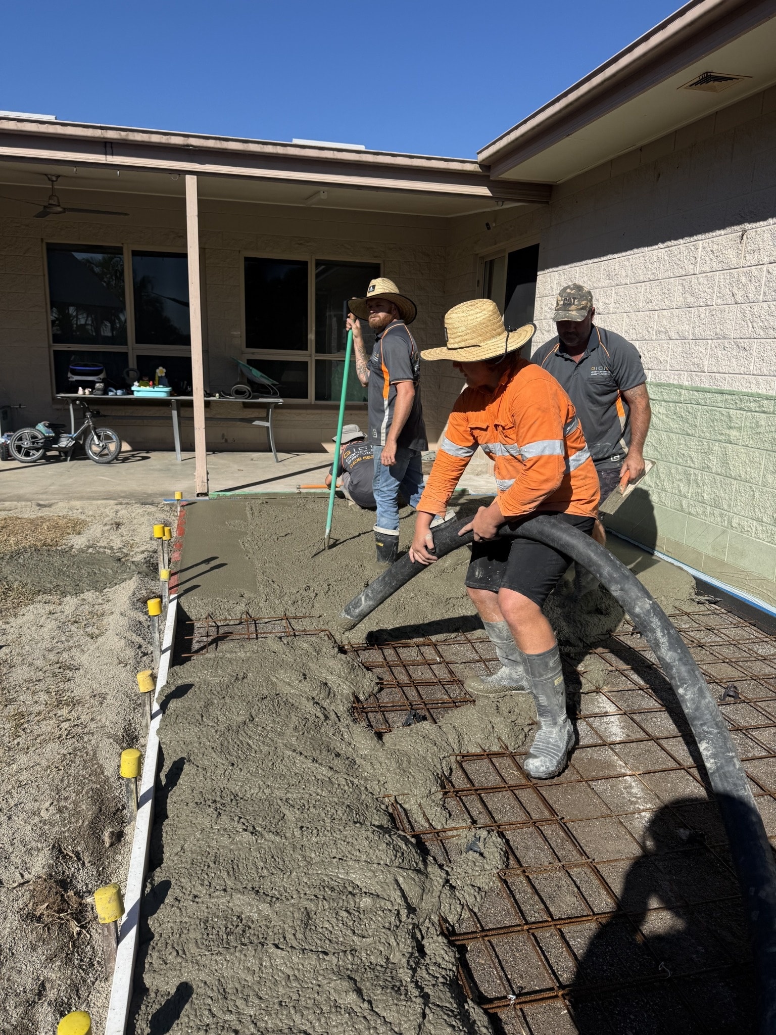 Shed slab pour with crew working at dusk